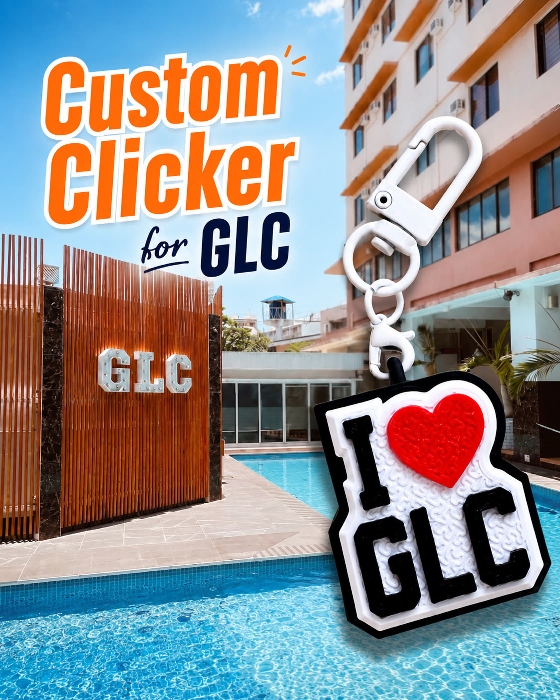 An I love GLC clicker keychain in black, white and red, shown in front of the school pool and the GLC logo wall