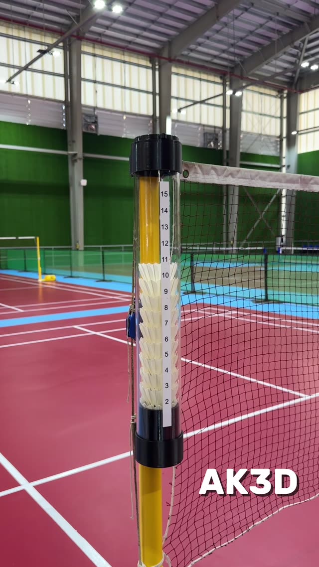 Clear tube shuttlecock holder attached to a badminton net pole